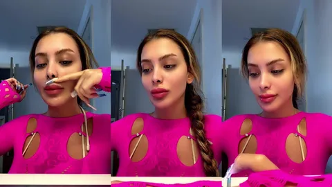 Celine Tango pembe kıyafetle saçını örerken poz veriyor